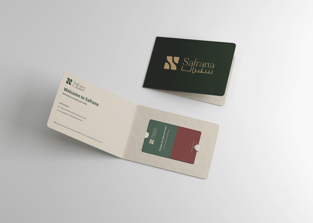 A dark green folder with gold "Safrana" logo lies beside an open welcome packet. Inside, a card holder with a card, accompanied by welcome text. Clean and elegant design.